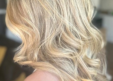 Blonde wavy hairstyle at Sacred Hair in North Shields, England, GB showcasing vibrant highlights.