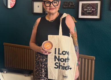 Visitor at Sacred Hair, North Shields, England, GB holding a branded bag and product.