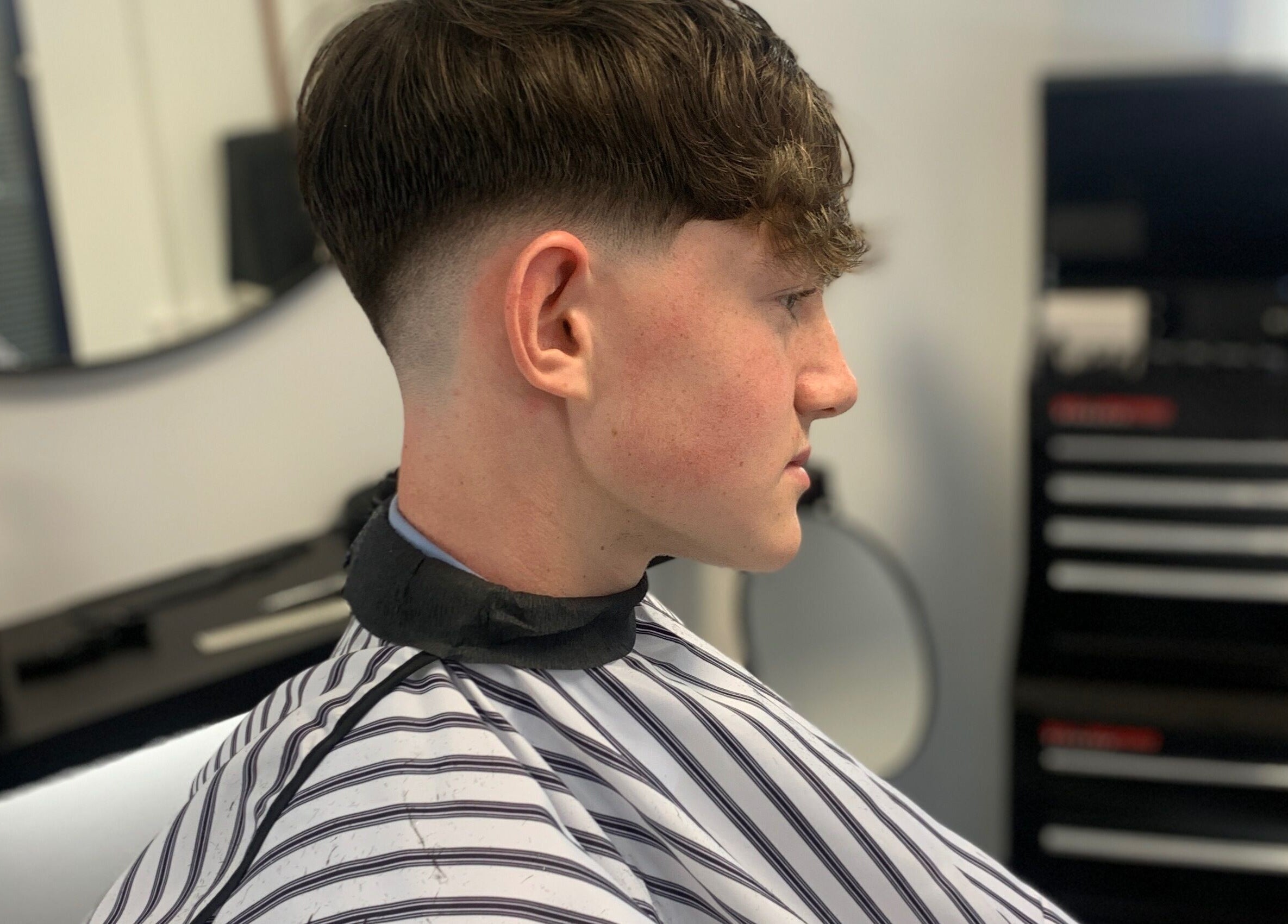 Side view of a stylish men's haircut at True Fadez, Castletown, Castletown, IM, showcasing a clean fade.