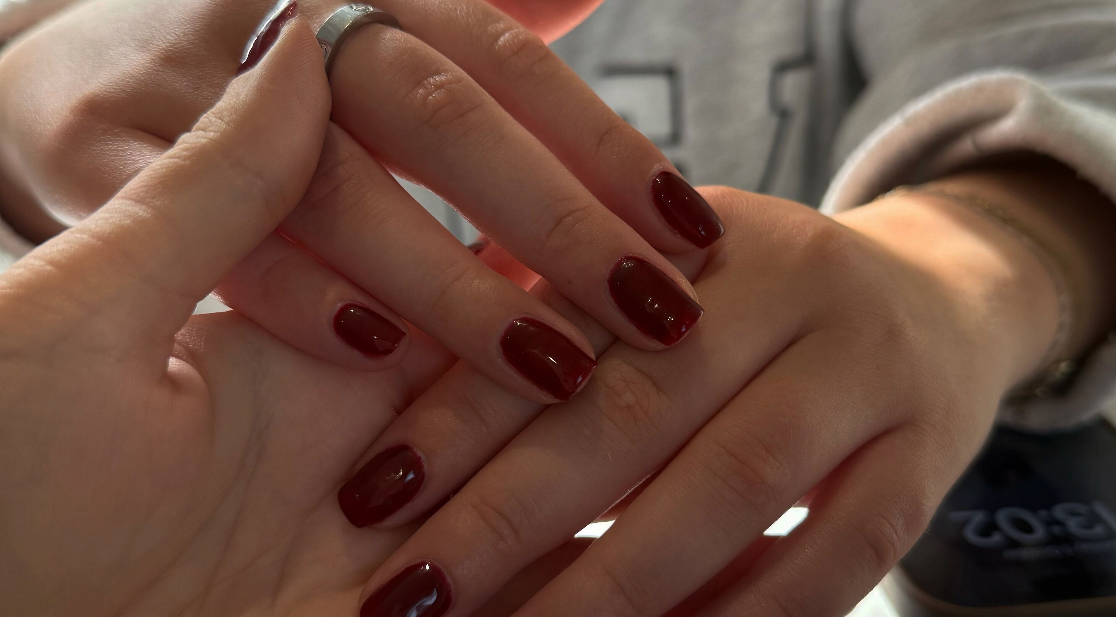 Close-up of freshly painted nails at Beauty By Chloe, Leeds, England, GB, featuring a rich burgundy color.
