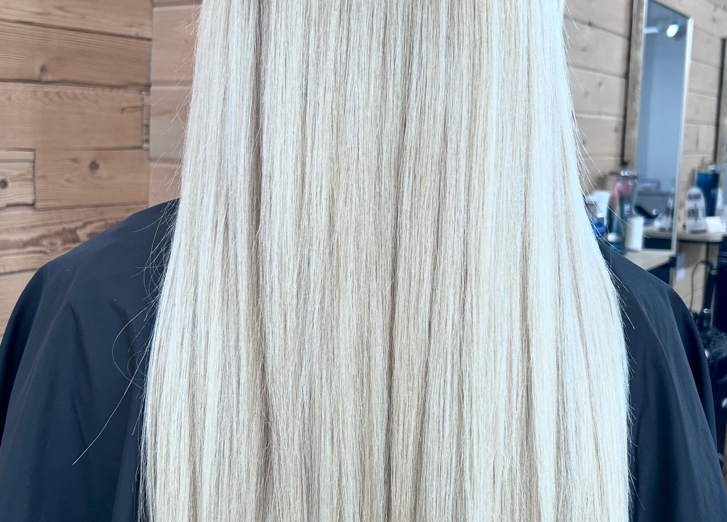 Sleek, long blonde hair styled at Meg's Studio, Orillia, Ontario, CA, showcases expert hair care.