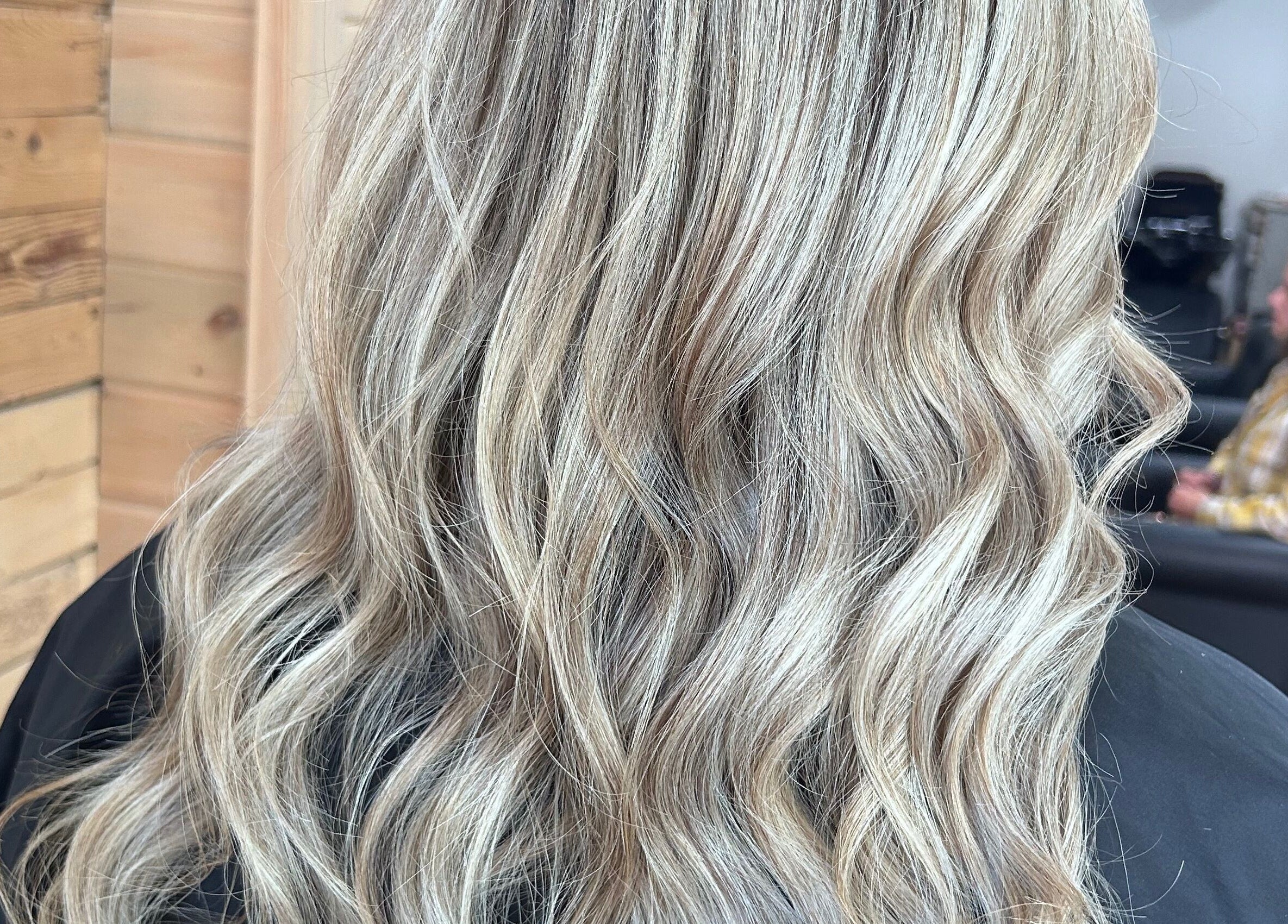 Blonde wavy hairstyle at Meg's Studio, Orillia, Ontario, CA, showcasing natural beauty and hair expertise.