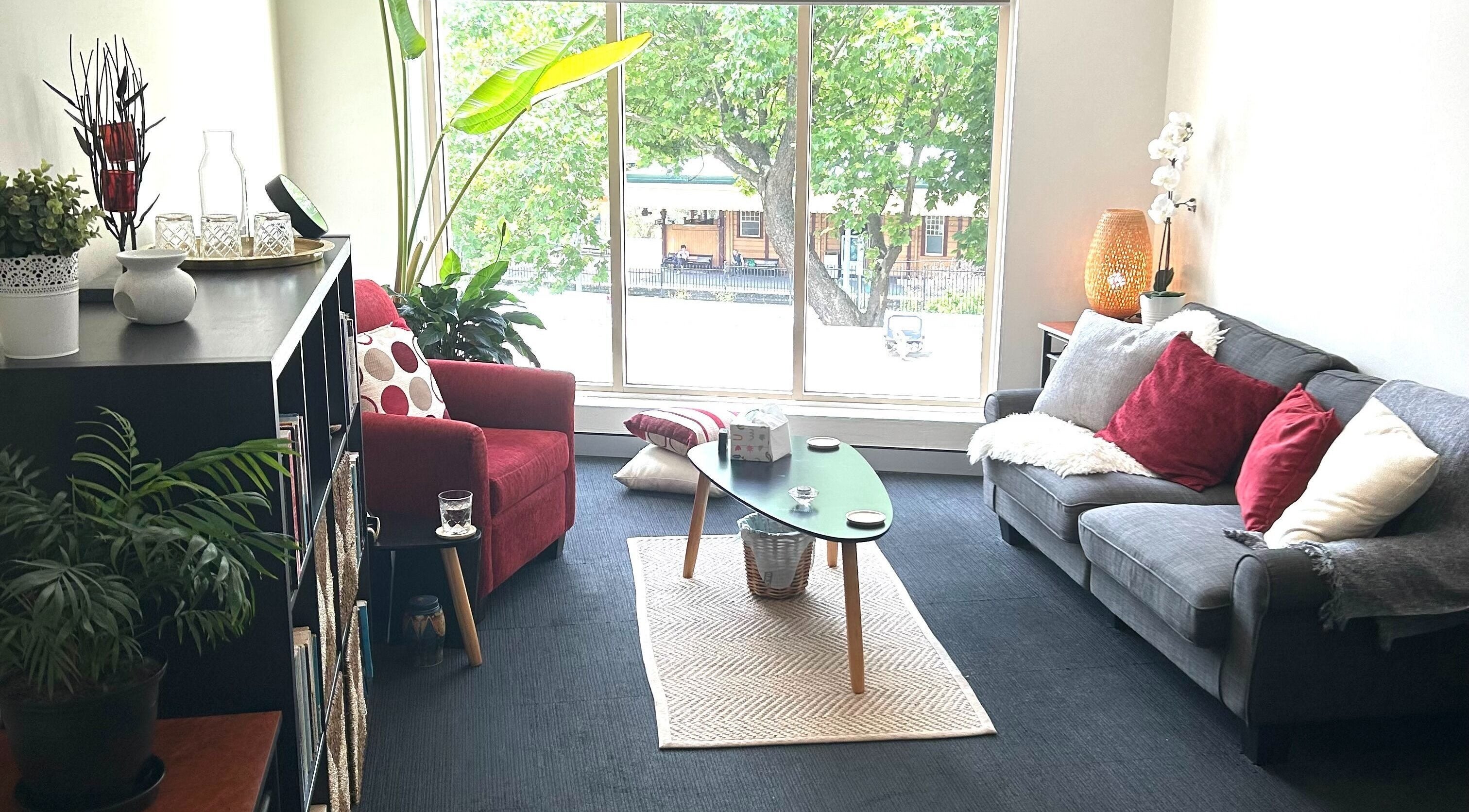 Bright, cozy therapy room at Blue Mountains Therapies, Katoomba, New South Wales, AU with sofa and plants.