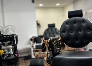 Cadeira de barbeiro em couro preto no MáximoBarber, Algés, Lisboa, PT, ambiente moderno e acolhedor.