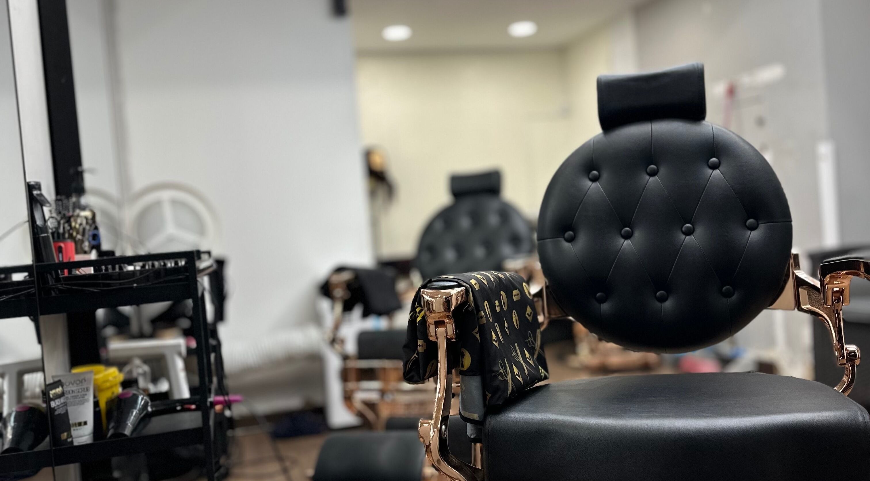 Cadeira de barbeiro em couro preto no MáximoBarber, Algés, Lisboa, PT, ambiente moderno e acolhedor.