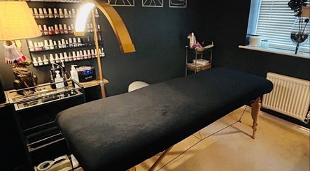 Cozy treatment room at Forever Young Beauty, Tongham, England, GB, featuring a massage table and nail polishes.