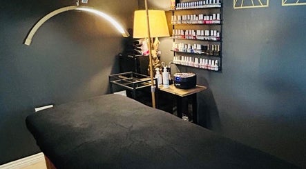 Relaxing massage room at Forever Young Beauty, Tongham, England, GB with treatment bed and nail polish display.