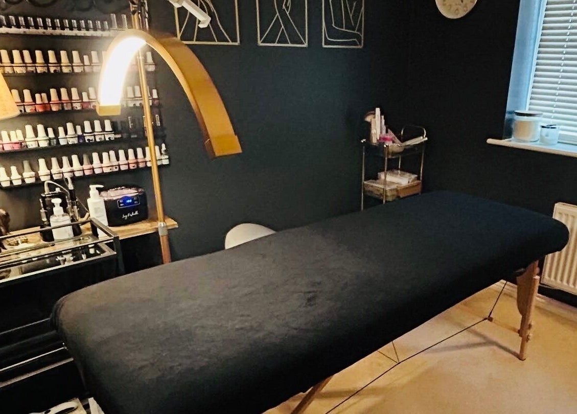 Relaxing treatment room at Forever Young Beauty, Tongham, England, GB with a cozy massage bed and products.