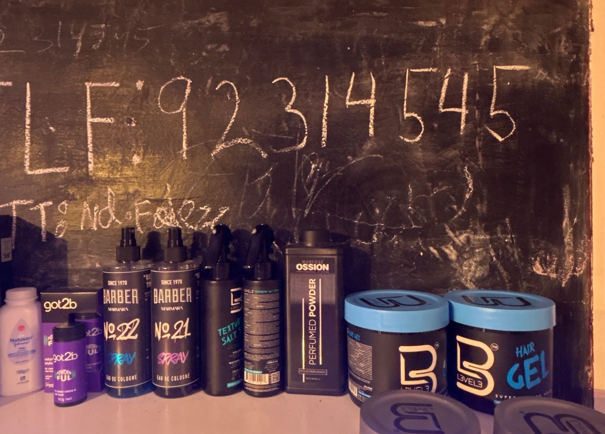 Hårprodukter på ND.fadezz i Hafrsfjord, Rogaland, NO, med en skrivevegg i bakgrunnen.