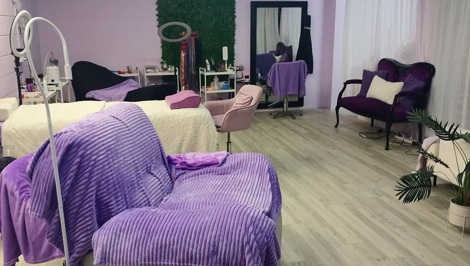 Relaxing beauty treatment room at Pretty's in Bellbird Park, Queensland, AU with purple decor and plush seating.