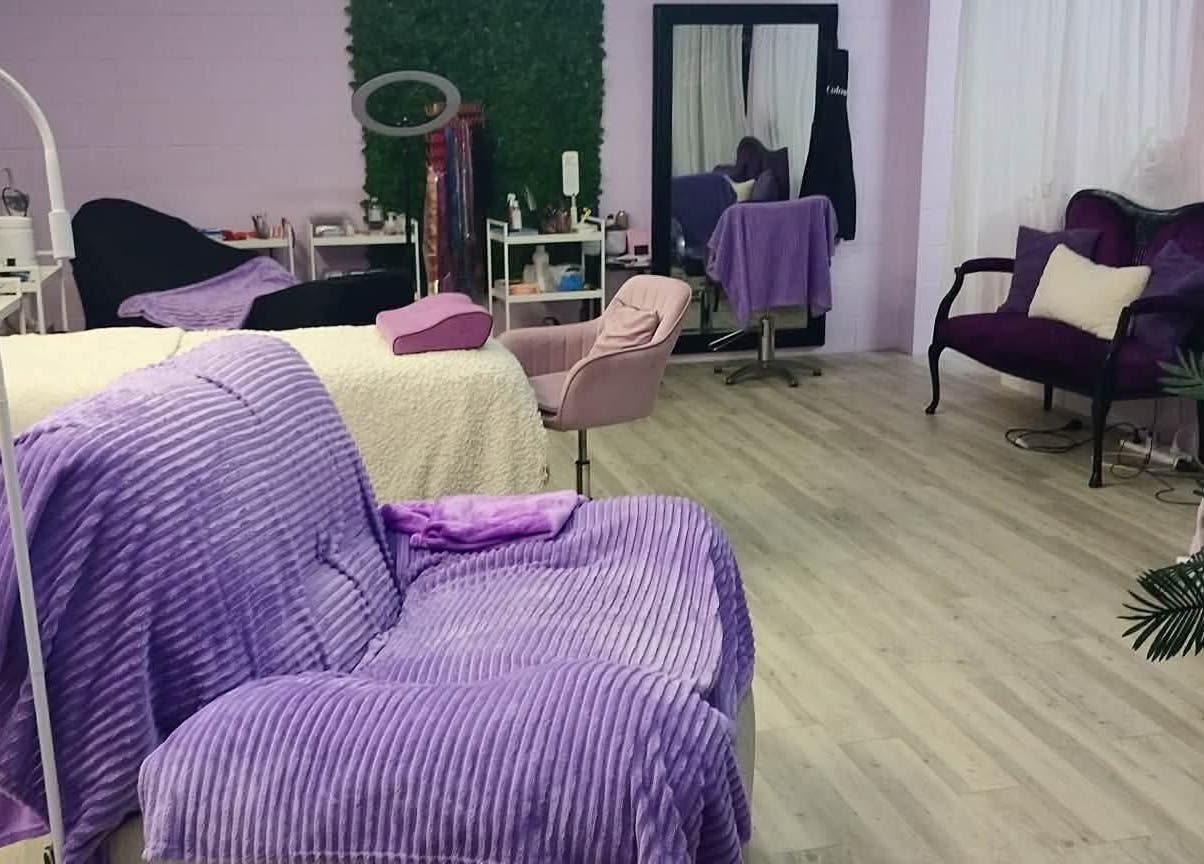 Relaxing beauty treatment room at Pretty's in Bellbird Park, Queensland, AU with purple decor and plush seating.