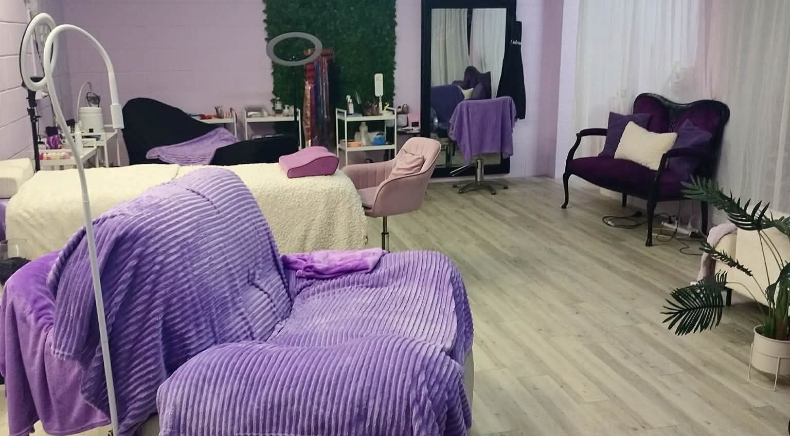 Relaxing beauty treatment room at Pretty's in Bellbird Park, Queensland, AU with purple decor and plush seating.