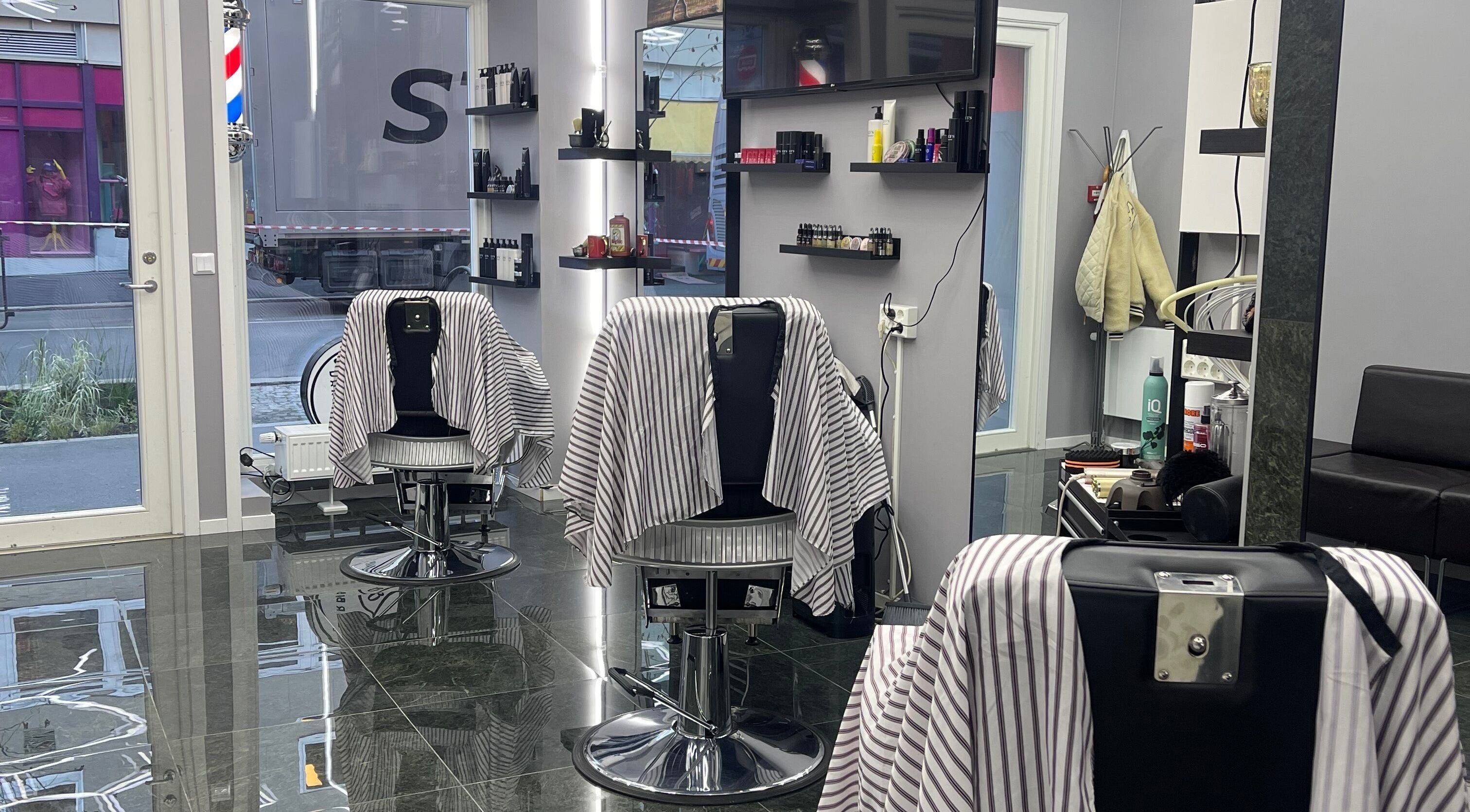 Modern interior of Rockbarbers in Oslo, Oslo, NO featuring sleek barber chairs and styling products.
