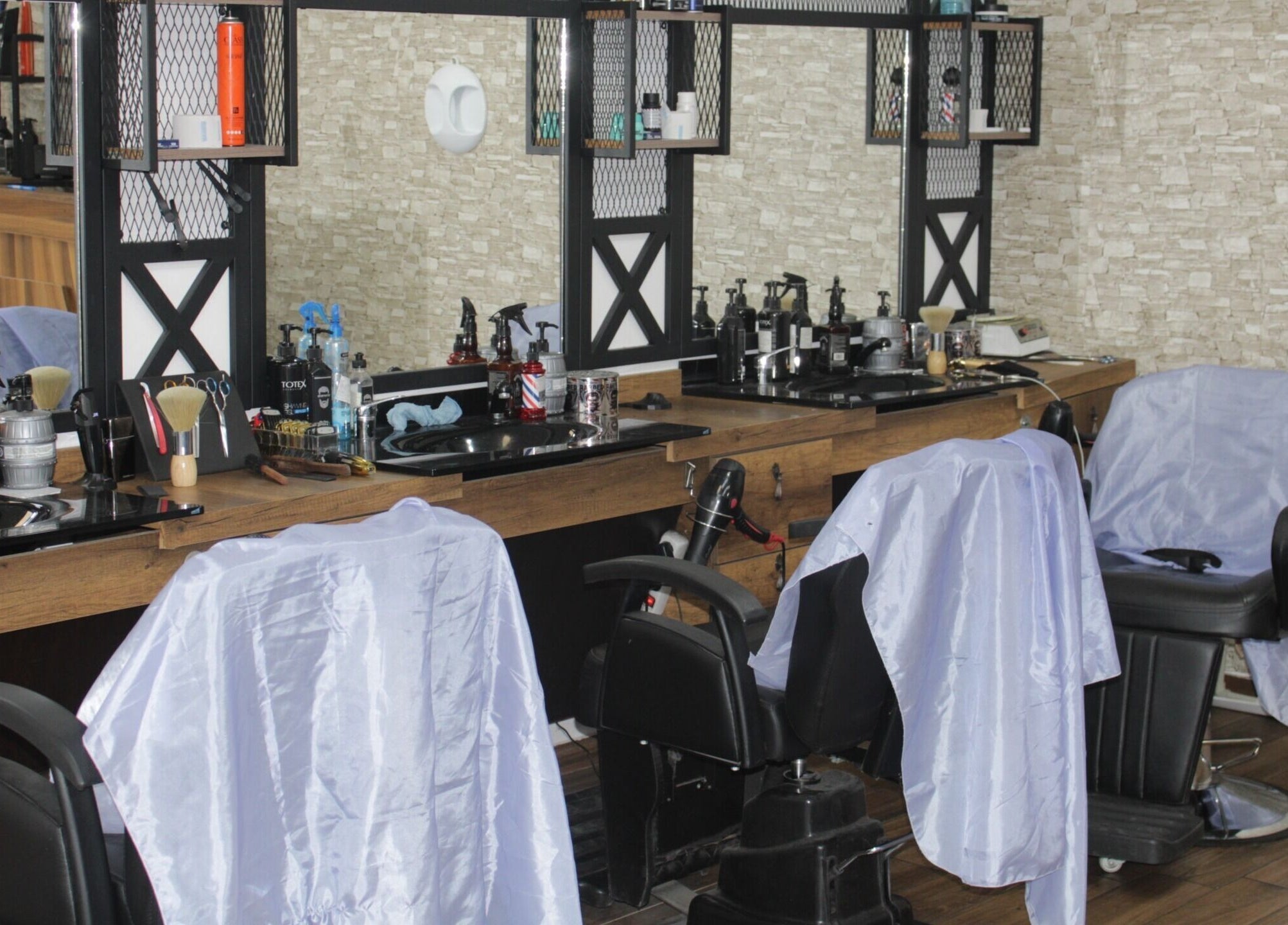 Интериор на BasriBarberShop в Пловдив, Plovdiv, BG, с елегантни фризьорски столове и инструменти.