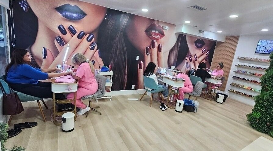 Interior de Acqua Nails & Wax en Doral, Florida, US, mostrando manicuristas trabajando bajo un mural llamativo.