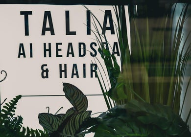 Talia Hair and Beauty Salon entrance sign in Singapore, SG, amidst lush greenery.