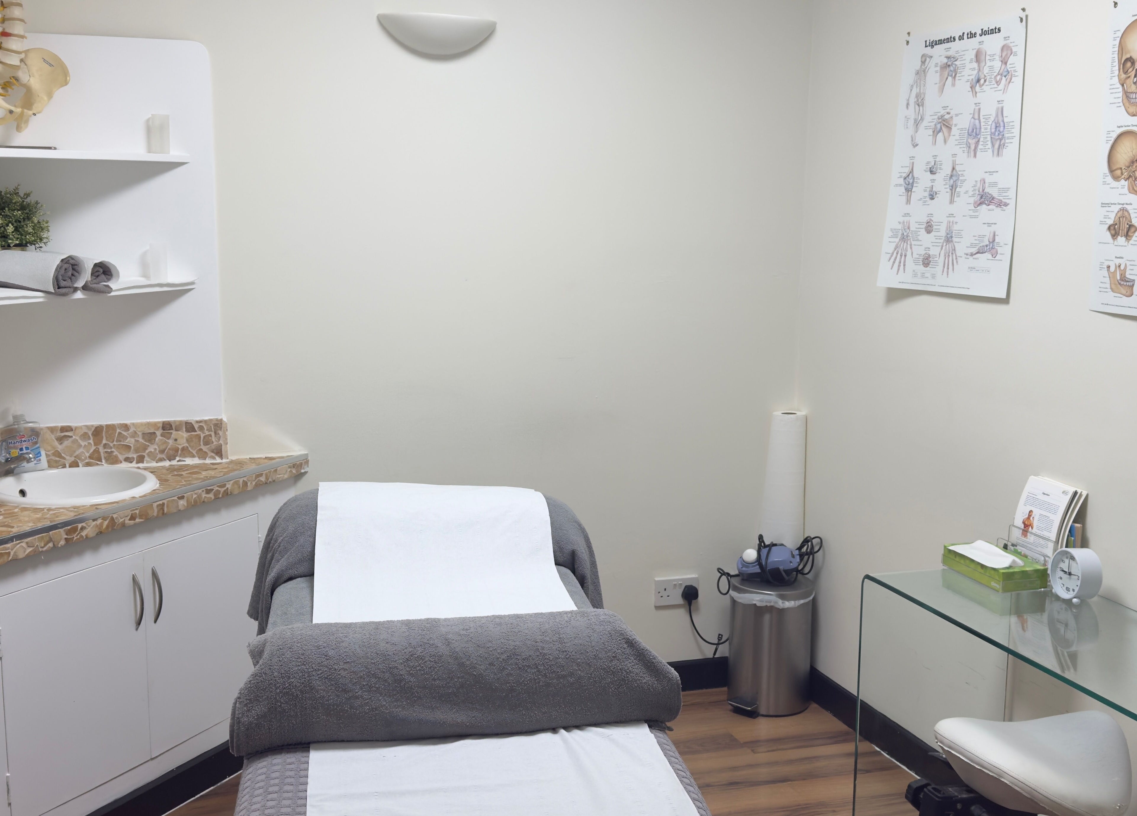 Treatment room at Mistry Osteopath South Ealing in London, England, GB with massage table and anatomical charts.