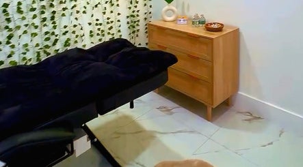 Sala de tratamiento en Beauty Studio Karem, Miramar, Florida, US, con cama de masaje y decoración natural.