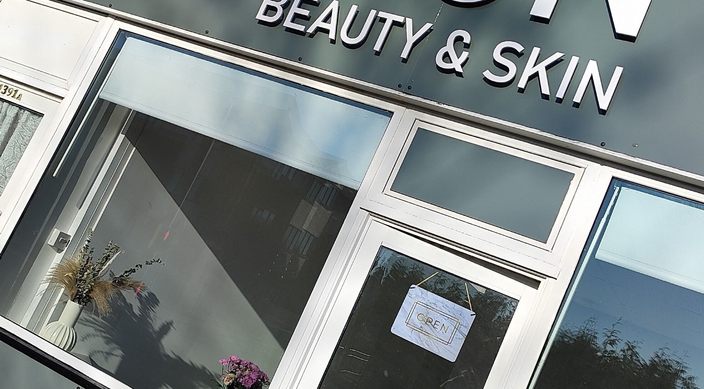 Front of Icon Beauty & Skin, Southend on Sea, England. Glass doors with open sign and decorative plants.