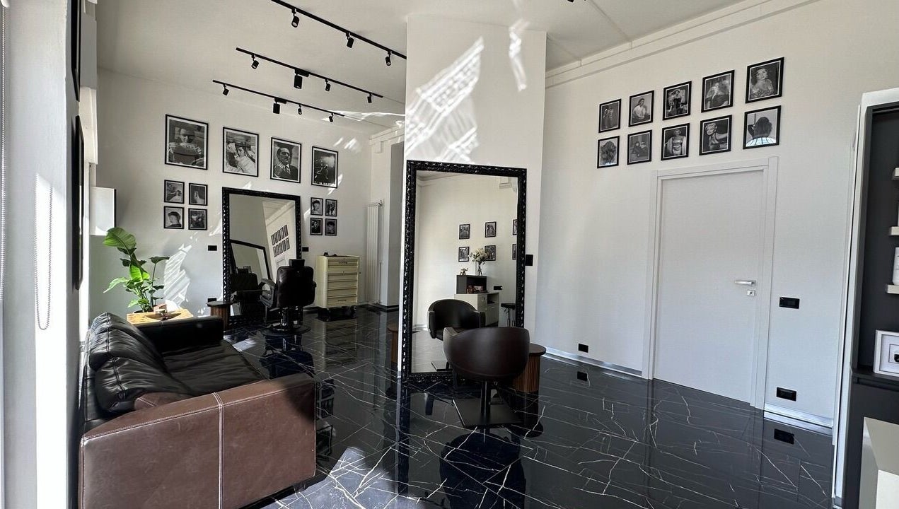 Interno elegante di Arena Hairstyle a Gallarate, Lombardia, IT con specchi e poltrone di lusso.