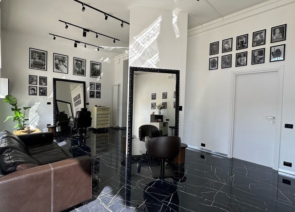Interno elegante di Arena Hairstyle a Gallarate, Lombardia, IT con specchi e poltrone di lusso.