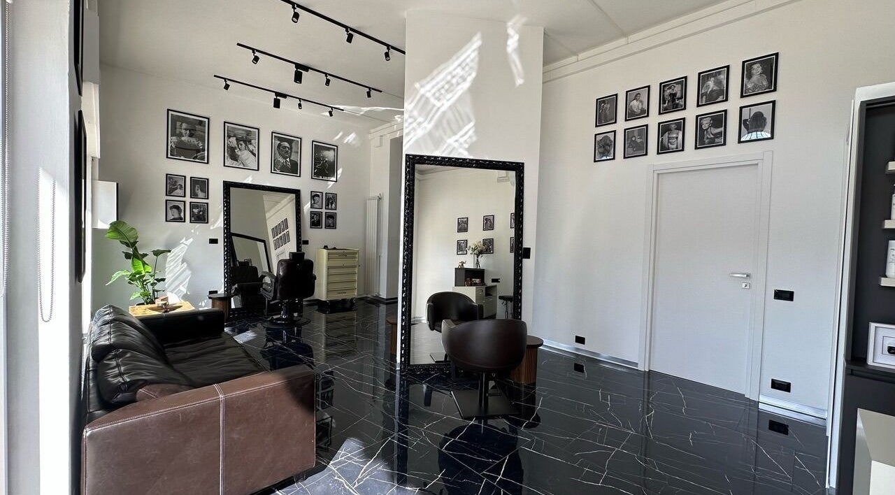 Interno elegante di Arena Hairstyle a Gallarate, Lombardia, IT con specchi e poltrone di lusso.