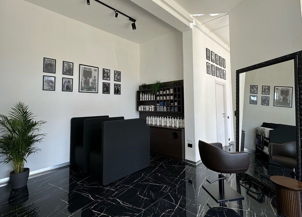 Interni moderni di Arena Hairstyle a Gallarate, Lombardia con arredi eleganti e foto artistiche al muro.