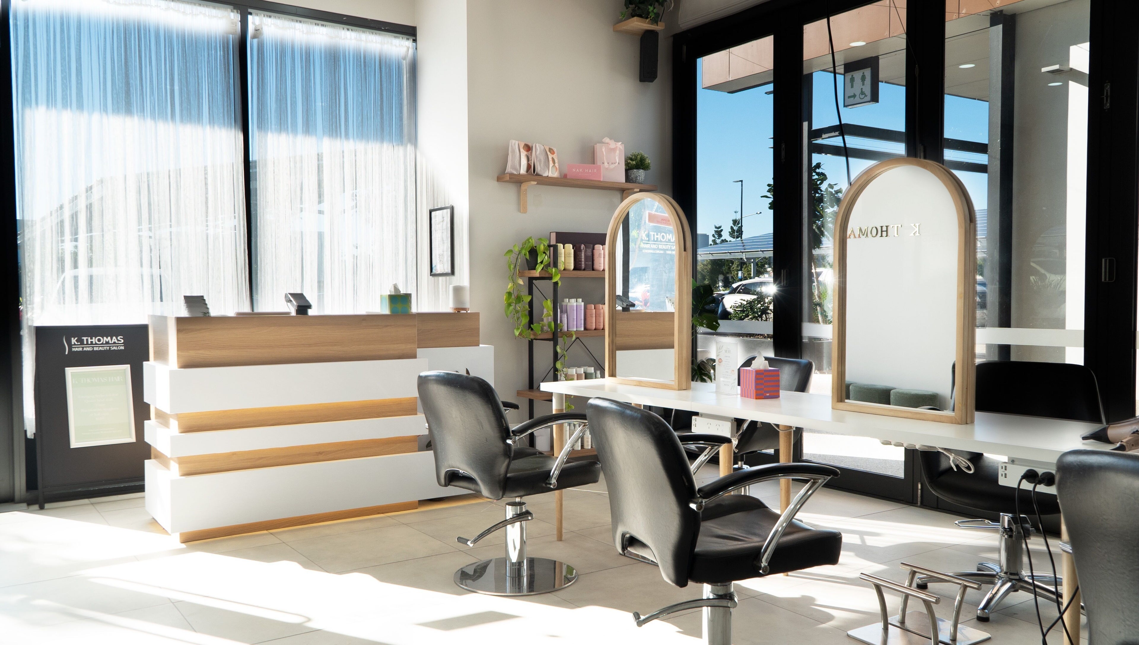 Bright salon interior at K Thomas Capestone Village, Mango Hill, Queensland, AU with sleek chairs and mirrors.