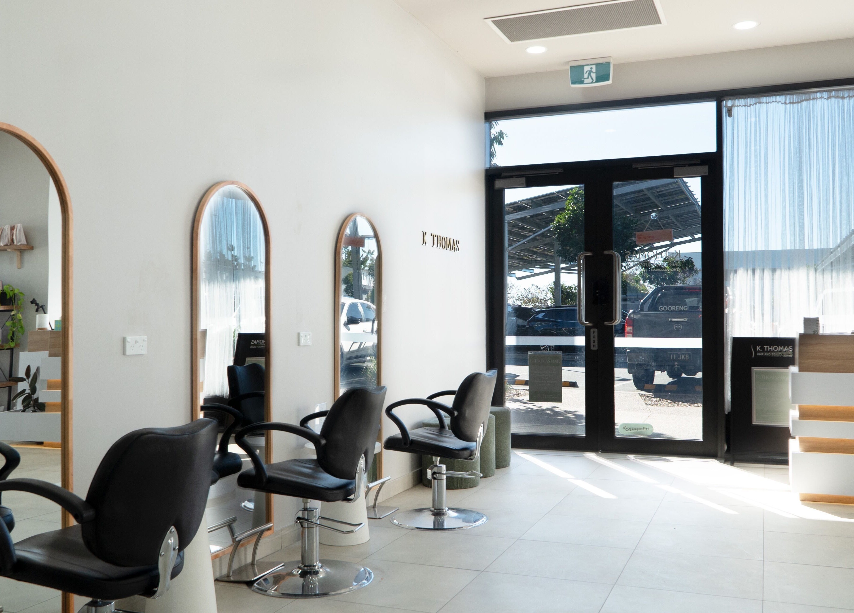 Modern salon interior at K Thomas Capestone Village, Mango Hill, Queensland, AU with stylish mirrors and chairs.