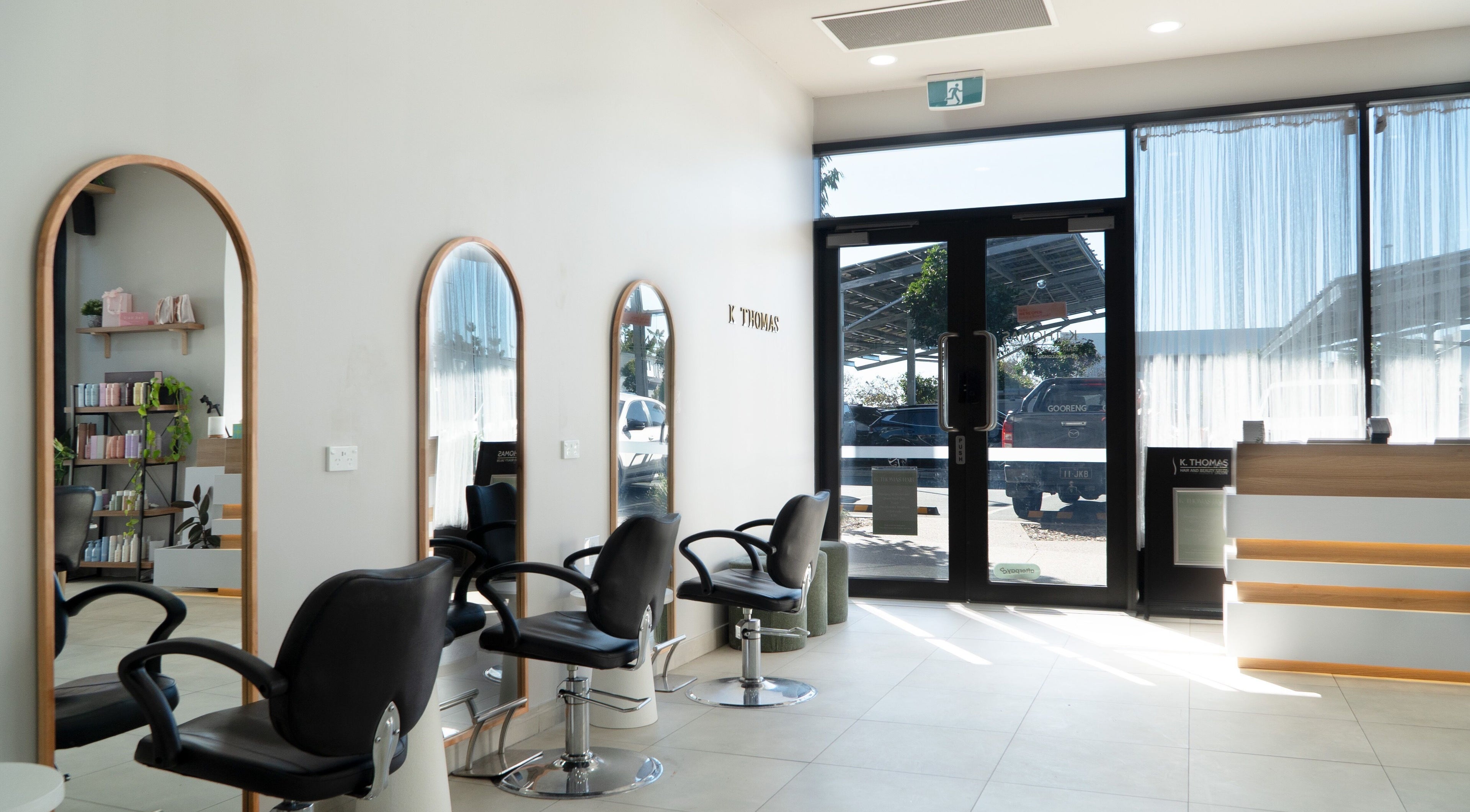 Modern salon interior at K Thomas Capestone Village, Mango Hill, Queensland, AU with stylish mirrors and chairs.