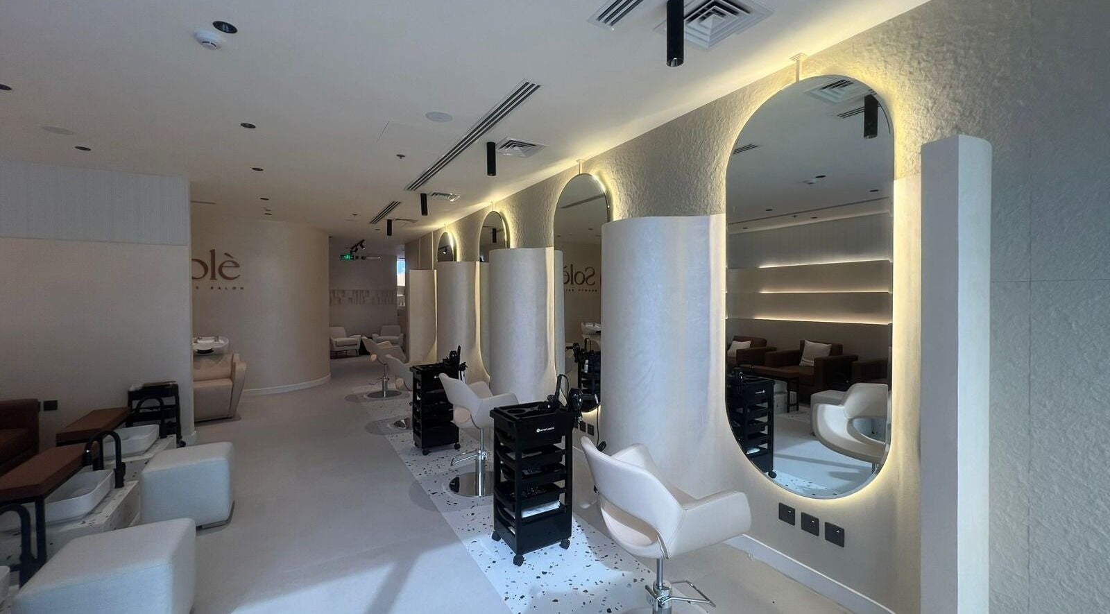 Modern, elegant interior of Solè beauty salon in الظهران, المنطقة الشرقية, SA with stylish seating and mirrors.