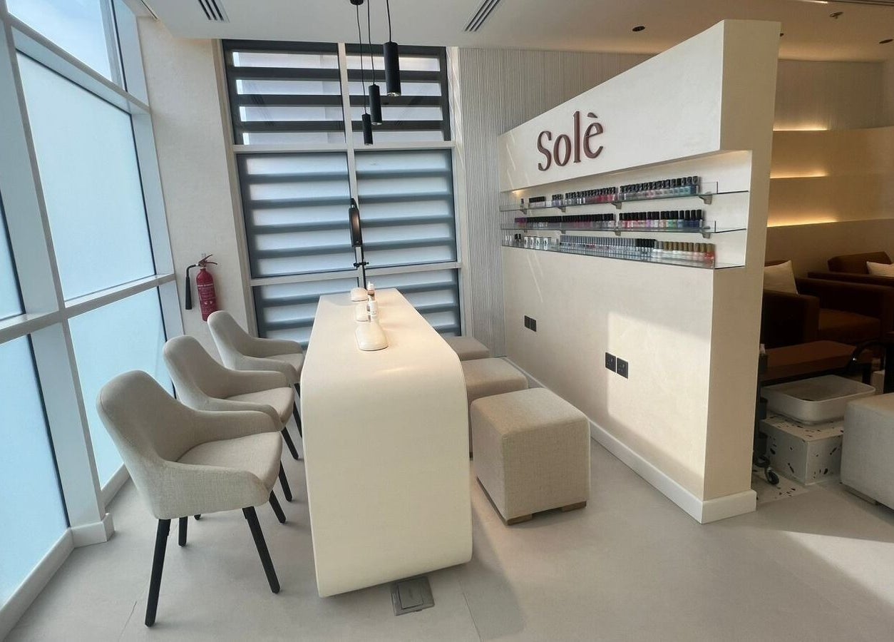 Modern nail bar in Solè, الظهران, المنطقة الشرقية, SA with elegant chairs and soft lighting.