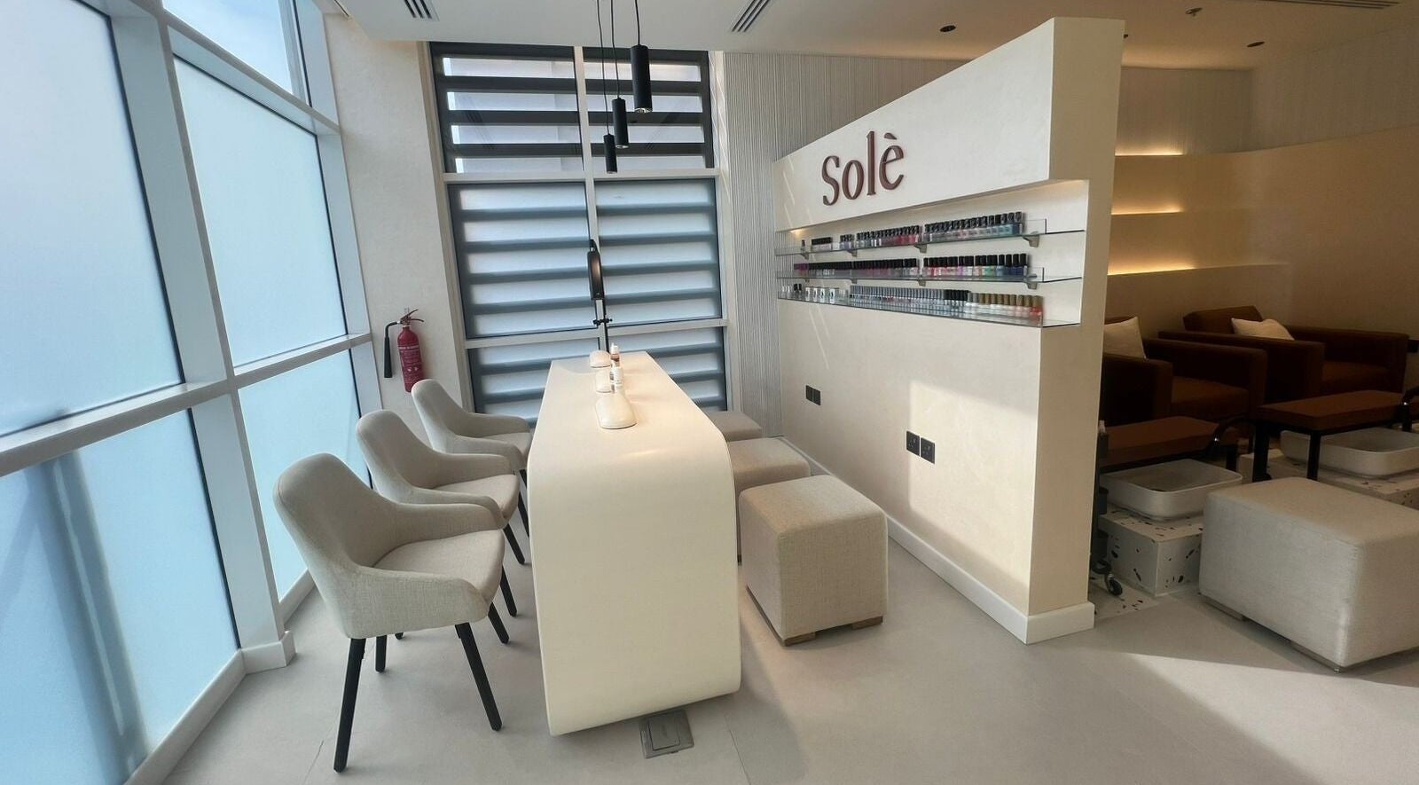 Modern nail bar in Solè, الظهران, المنطقة الشرقية, SA with elegant chairs and soft lighting.