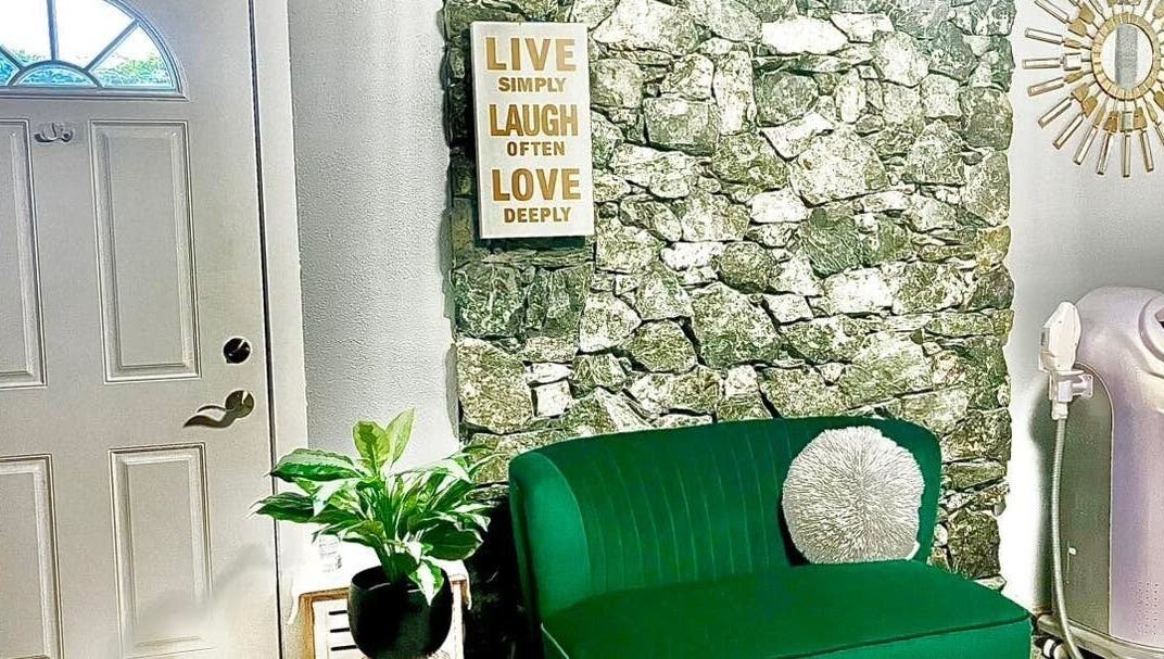 Welcoming nook at Sandy’s H&M in Duncan, BC, with a green couch and wall art inviting relaxation.