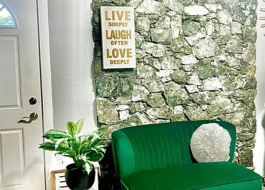 Welcoming nook at Sandy’s H&M in Duncan, BC, with a green couch and wall art inviting relaxation.
