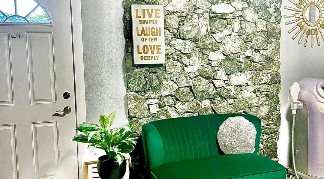 Welcoming nook at Sandy’s H&M in Duncan, BC, with a green couch and wall art inviting relaxation.