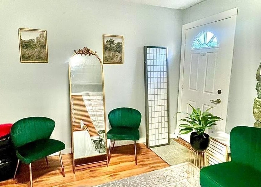 Cozy seating area in Sandy’s H&M, Duncan, British Columbia. Elegant decor with green chairs and a mirror.
