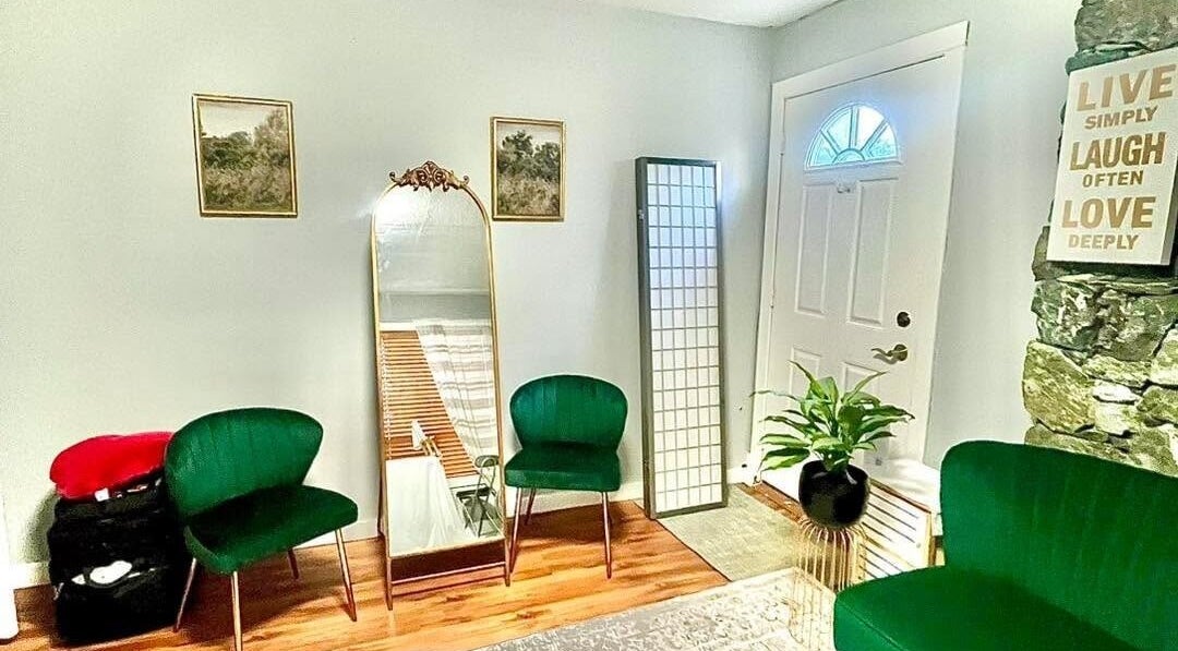 Cozy seating area in Sandy’s H&M, Duncan, British Columbia. Elegant decor with green chairs and a mirror.