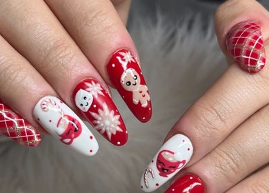 Festive holiday-themed nails at Nailz By Sandy in Adjala-tosorontio, Ontario, CA. Red and white intricate designs.