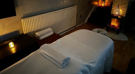 Warmly lit massage room at B Therapy in Grays, England, GB with towels and candles.