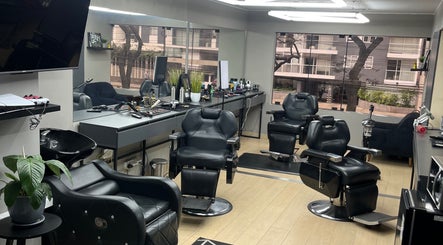 Interior moderno de Victory Barber Studio en Miraflores, Provincia De Lima, PE con sillas de peluquería negras.
