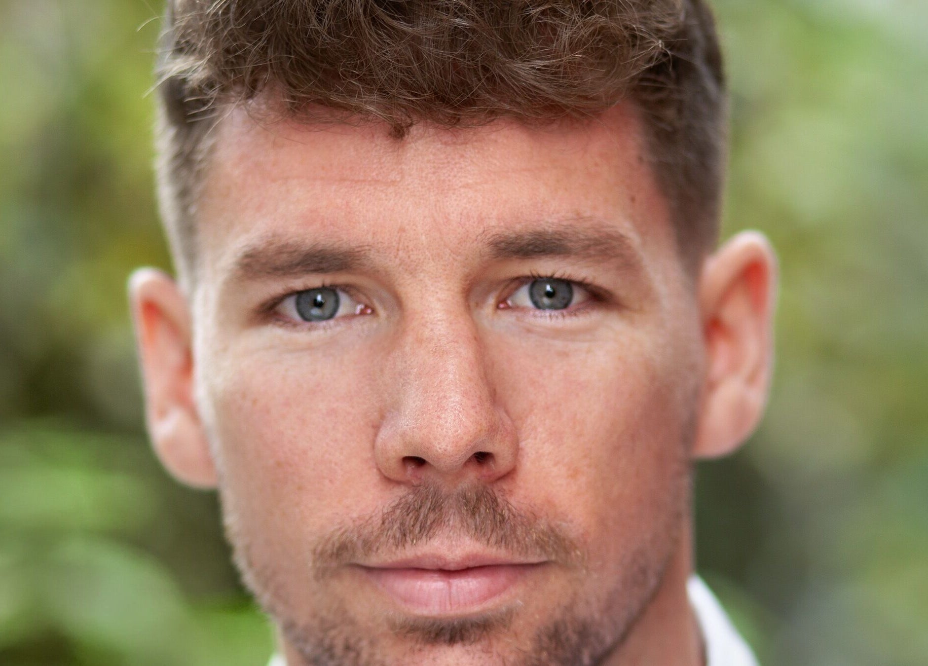 Close-up of a serene person outside Fibres Sports Massage Therapy in Alcester, England, GB.