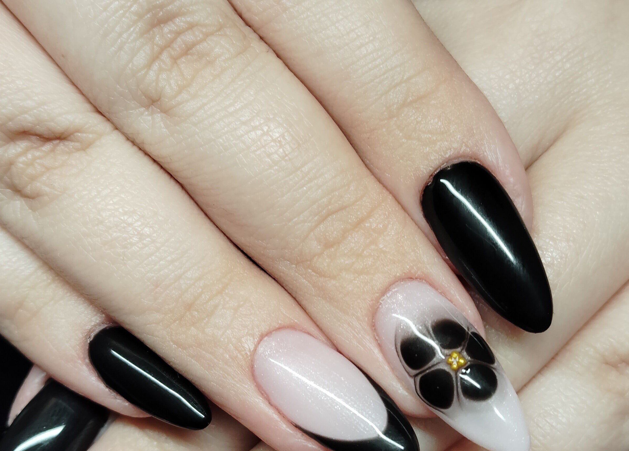 Manucure sophistiquée chez Nails'Hair by Flo, Cubrial, Bourgogne-franche-comté, FR avec design floral noir.
