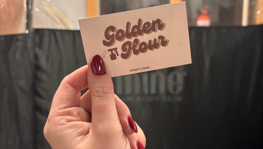 Hand holds Golden Hour business card at Gore, Southland, NZ spray tan venue.