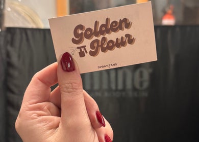 Hand holds Golden Hour business card at Gore, Southland, NZ spray tan venue.
