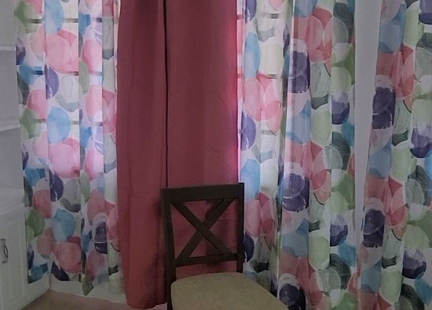 Brightly colored curtains and a cozy chair at Demure Aesthetics, 6729+8V Providence, Tobago, TT.