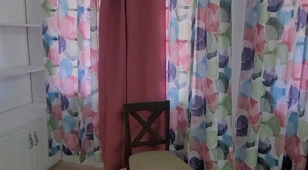 Brightly colored curtains and a cozy chair at Demure Aesthetics, 6729+8V Providence, Tobago, TT.
