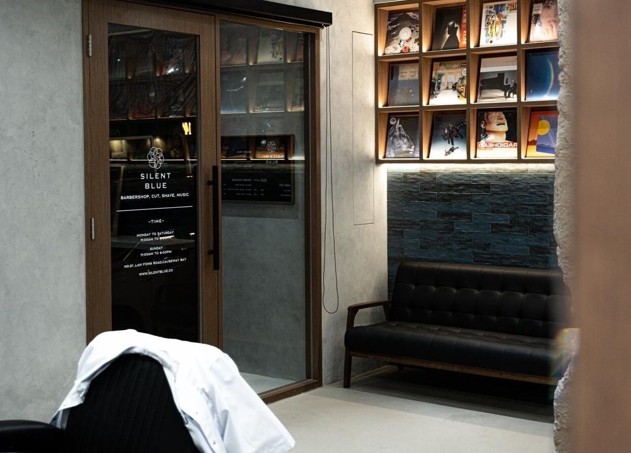 Interior of Silent Blue Barbershop with stylish decor in Hong Kong, HK, featuring modern seating and artwork.