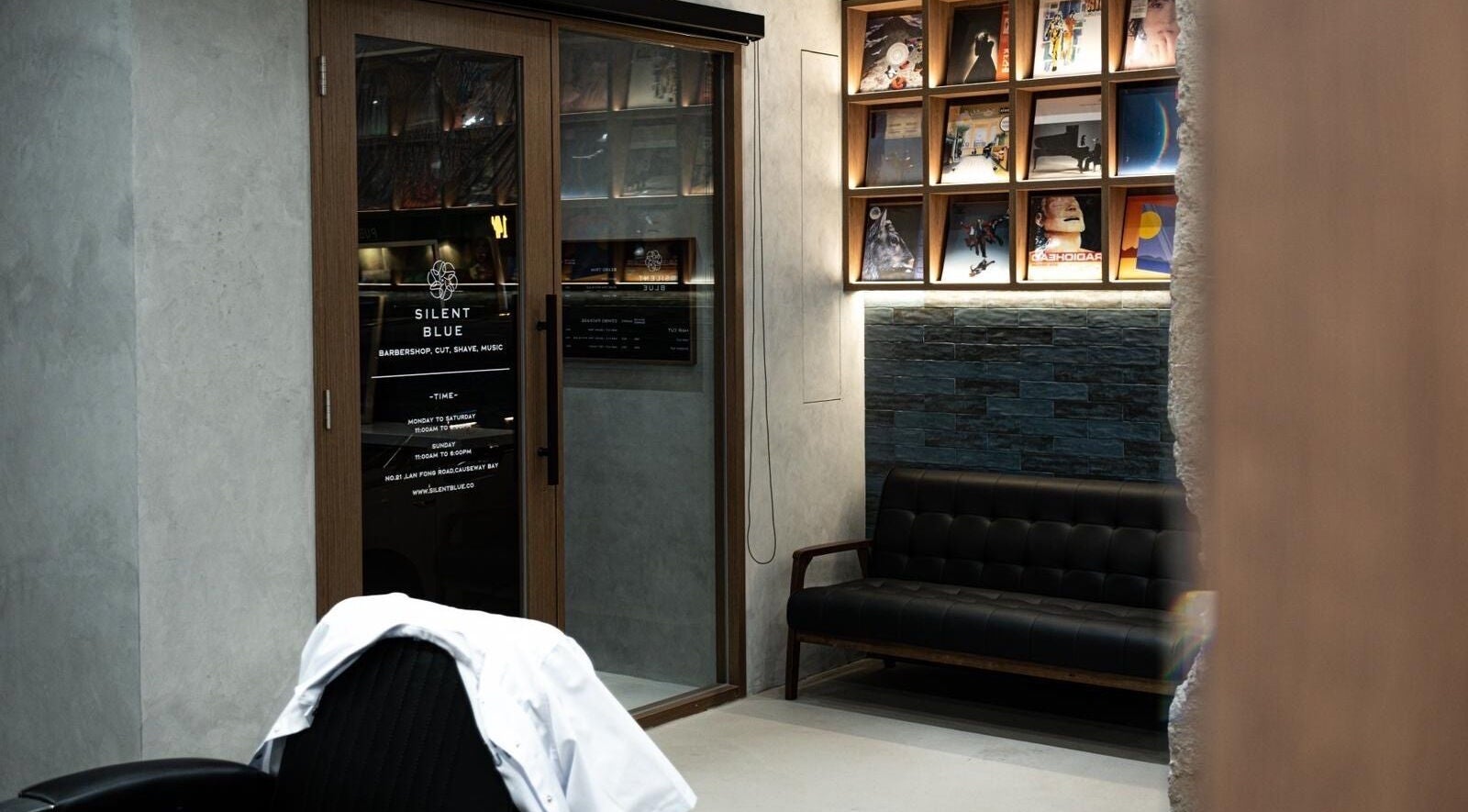 Interior of Silent Blue Barbershop with stylish decor in Hong Kong, HK, featuring modern seating and artwork.