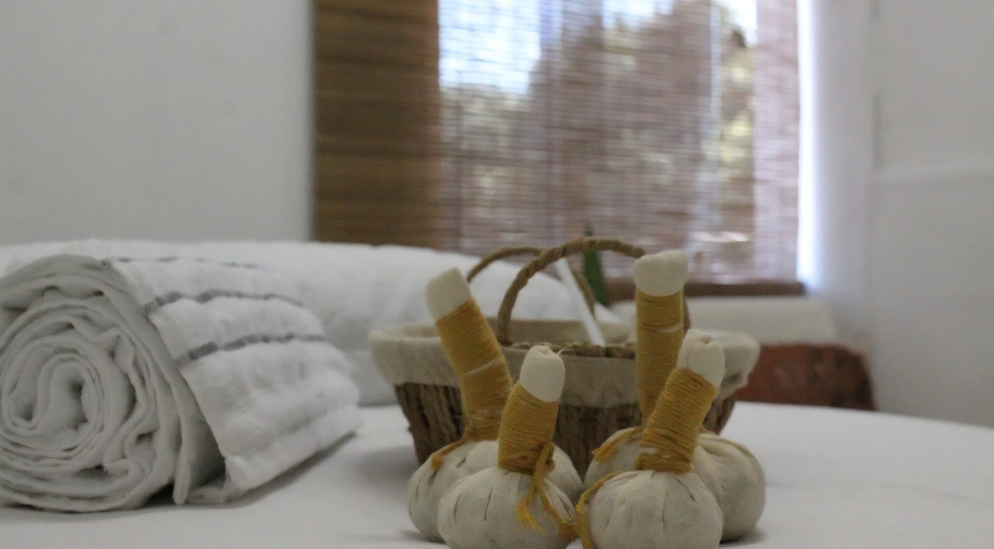 Cinthia Gimenes | Massoterapia em Indaiatuba, São Paulo, BR - mesa de massagem com ervas e toalhas.